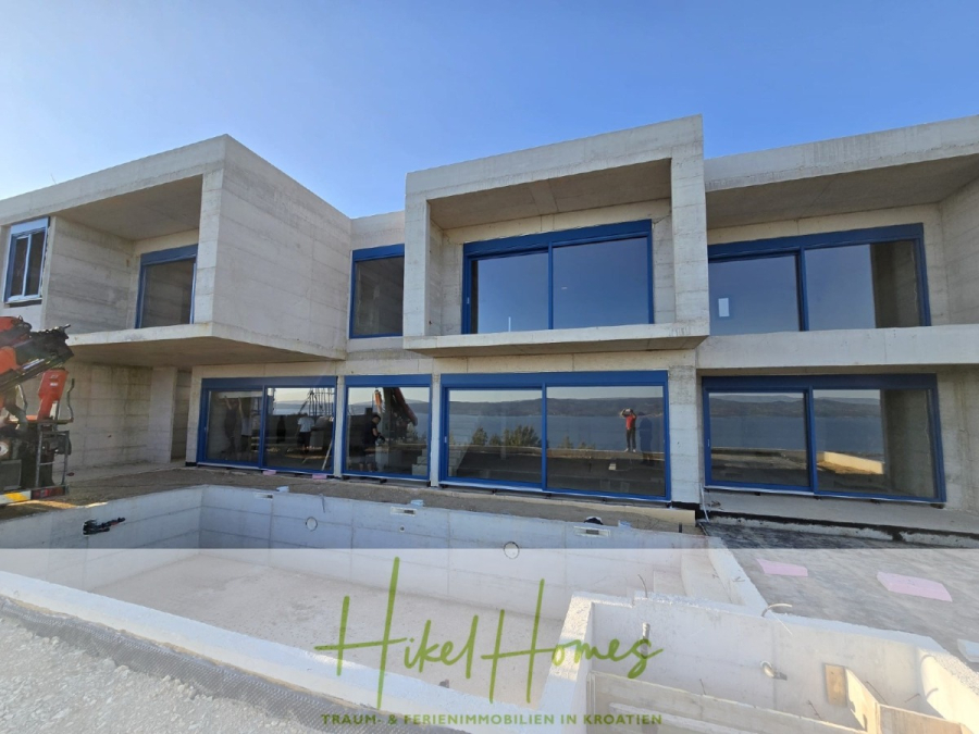 Schlüsselfertige – großzügige Meerblick Villa in ruhiger Lage, 4 SZ, 4 Bäder, Pool, … - Modernes zweistöckiges Betonhaus im Bau mit großen Fenstern und Blick auf das Meer. Im Vordergrund ist ein leeres Schwimmbad zu sehen, und rund um die Baustelle sind Baumaschinen und Materialien zu sehen. (45175)