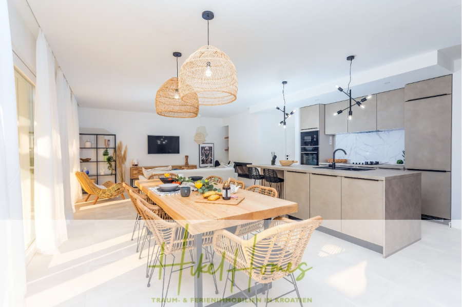 4 Schlafzimmer / 32m² Pool / Sommerküche – Neubauhaus nur 8km von Omis entfernt - Moderne, geräumige Küche und Essbereich mit natürlichem Licht, gedecktem Holztisch, Korbstühlen, Hängelampen und einer eleganten, neutral getönten Küche mit Einbaugeräten. (44114)