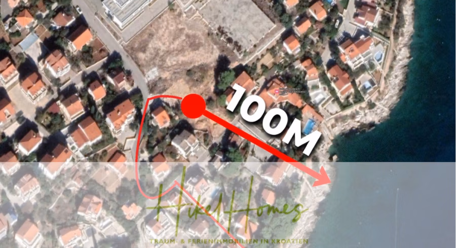 Luxus Meerblick 77m² Ensemble mit 2 Schlafzimmern, Terrasse und Südausrichtung (1. OG) - Eine Satellitenaufnahme eines Küstenwohngebiets mit Häusern mit roten Dächern; ein roter Pfeil und ein Punkt zeigen die Entfernung von 100 Metern zwischen den Häusern und dem Ufer an. Unten erscheint der Text „Nikhel Homes“. (43853)